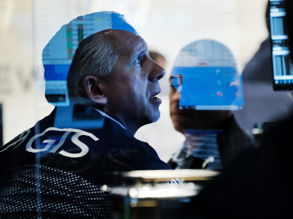 Traders work on the floor of the New York Stock Exchange at the start of trading on Monday following Friday's steep decline in global stocks over fears of the new omicron coronavirus variant discovered in South Africa.