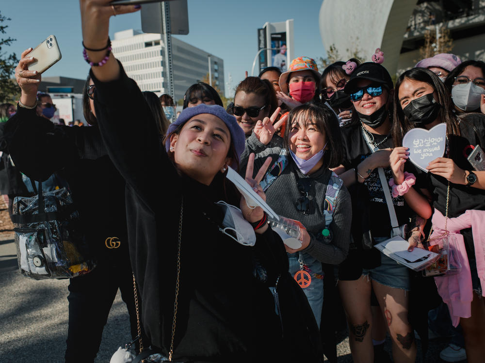 Two separate groups of fans from the Philippines take a photo together before the BTS concert at SoFi Stadium in Inglewood, Calif., on Nov. 27.