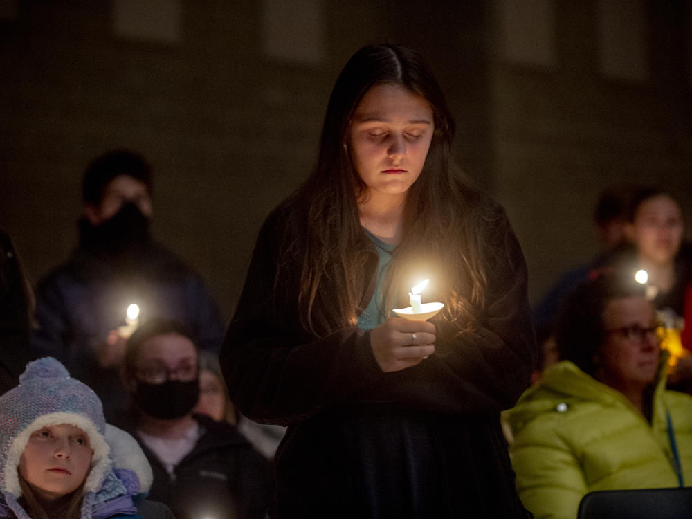 Students hold candles during a prayer vigil after the shootings at Oxford High School on Tuesday in Oxford, Mich.