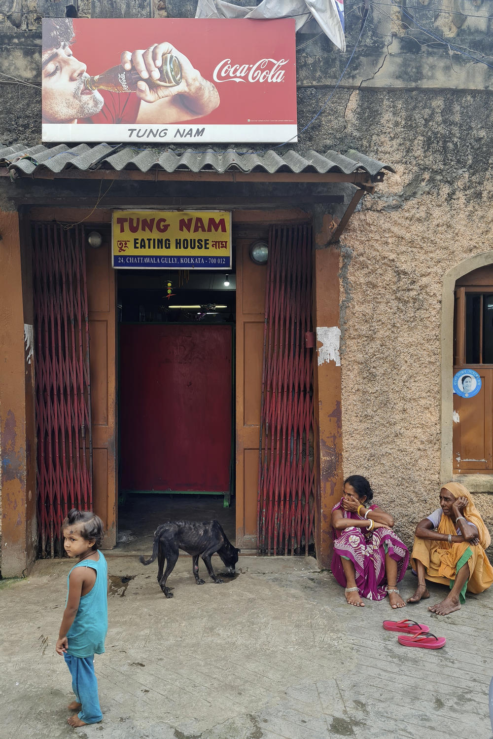 Women sit outside the entrance to the Tung Nam restaurant in Kolkata. It's run by a Chinese Indian, Susan Yee, and serves a mix of Chinese and Indian dishes.