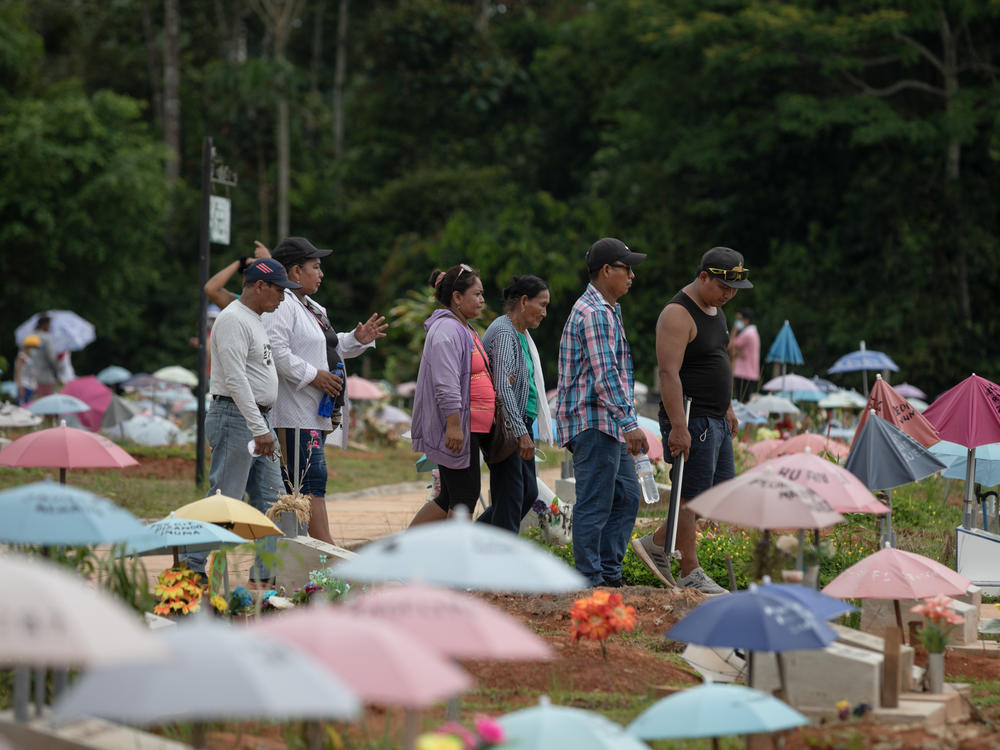 Ahuanari family visits the San Juan Bautista cemetery, a place where they would like to bury their mother after exhuming her from the common grave for the deceased by coronavirus in Iquitos, Peru.