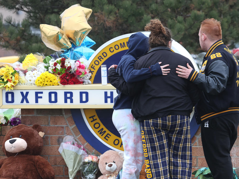 People embrace as they visit a makeshift memorial outside of Oxford High School on Wednesday in Oxford, Mich.