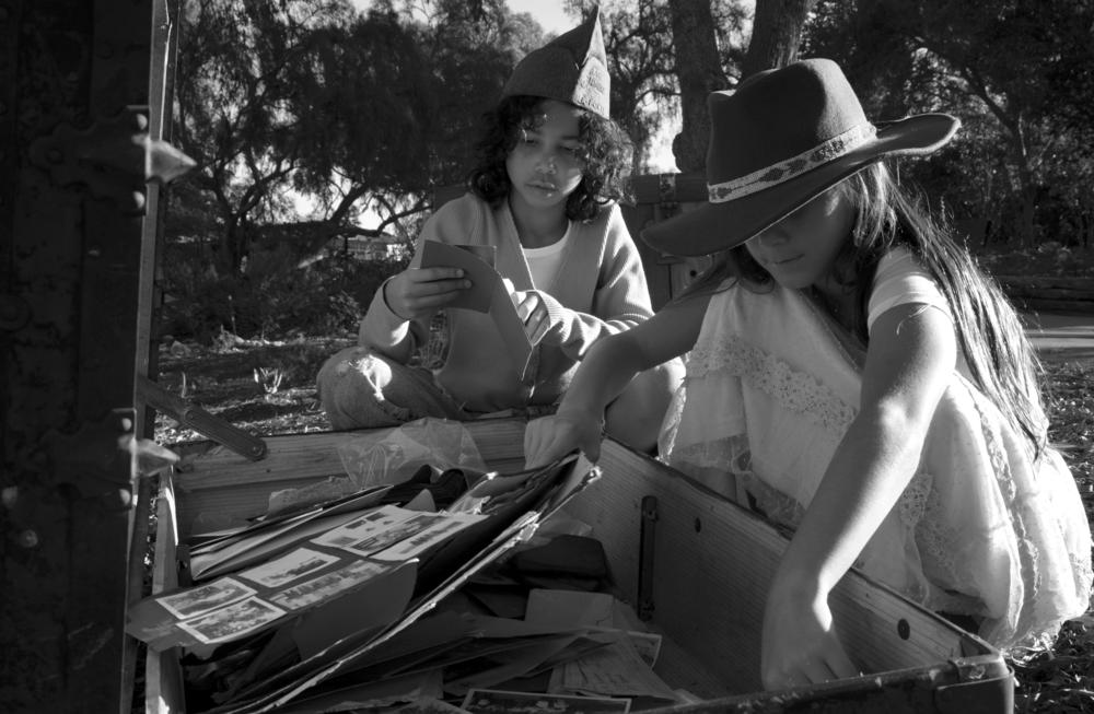 Elle Barnes,10, wears her Great Great Grandfather's U.S. army cap as she sifts through the contents of the trunk with her cousin Keala Sabla, 10, on Thanksgiving day in Los Angeles, CA.