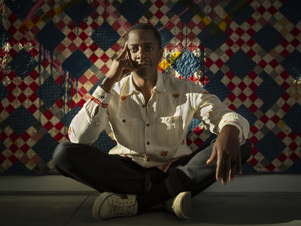 Artist Sanford Biggers' sits in front of his <em>Codex</em>, a textile work that includes paintings and sculptures done directly on or made from old quilts.