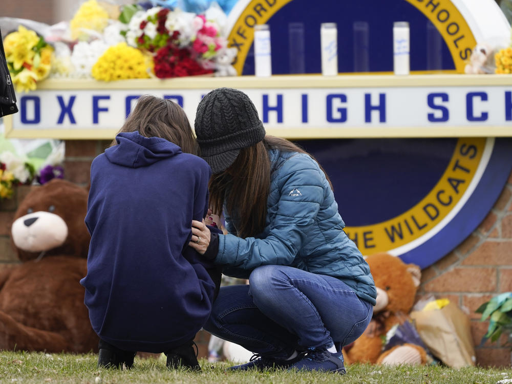 Mourners grieve at Oxford High School in Oxford, Mich., on Wednesday, the day after a gunman opened fire at the school, killing four students and wounding seven other people.