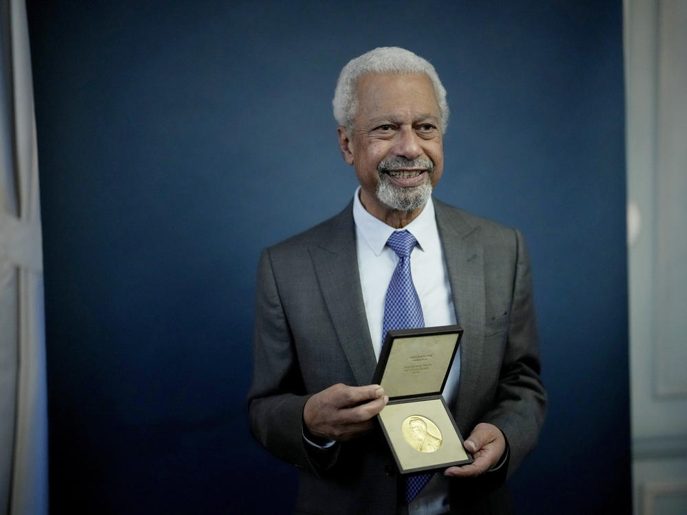 Abdulrazak Gurnah, a Tanzanian-born novelist and academic who lives in the U.K., poses with his 2021 Nobel Prize in Literature medal after being presented it at the Swedish ambassador's residence in London.
