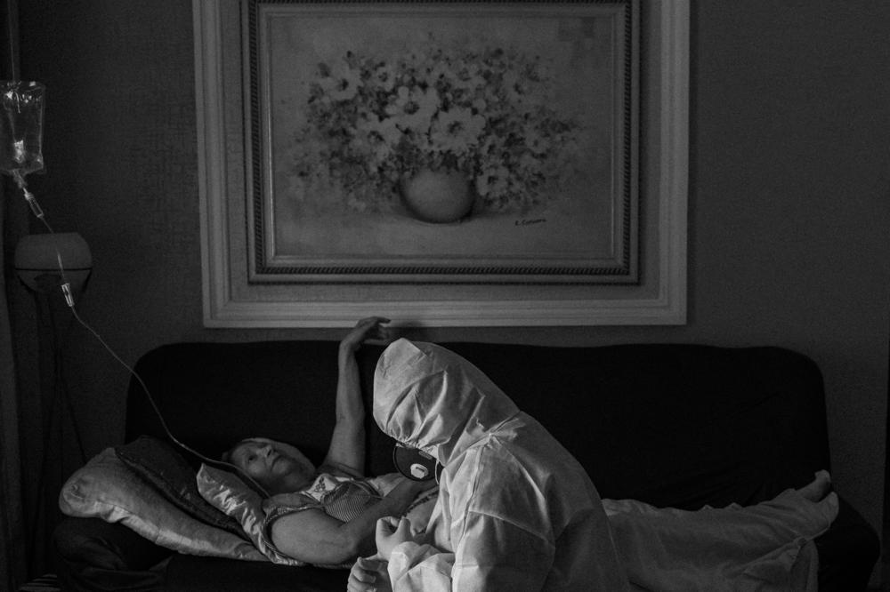 Alessandra Said, a 45-year-old doctor, assists her own mother, Maria da Consolação Said, 77, who has COVID-19 and also cancer, at her home in Manaus, on May 2, 2020. After finding out her mother was sick with COVID-19, the doctor asked for authorization to personally check her mother's health.
