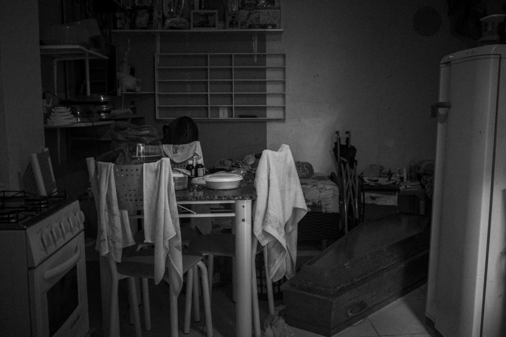 A coffin for someone who died from COVID-19 sits, with lunch still on the table next to it, inside the only room of a house in the poor neighborhood of Colonia Oliveira Machado, in southern Manaus, on May 7, 2020. Workers with a municipal social welfare program, SOS Funeral, later took away the coffin.