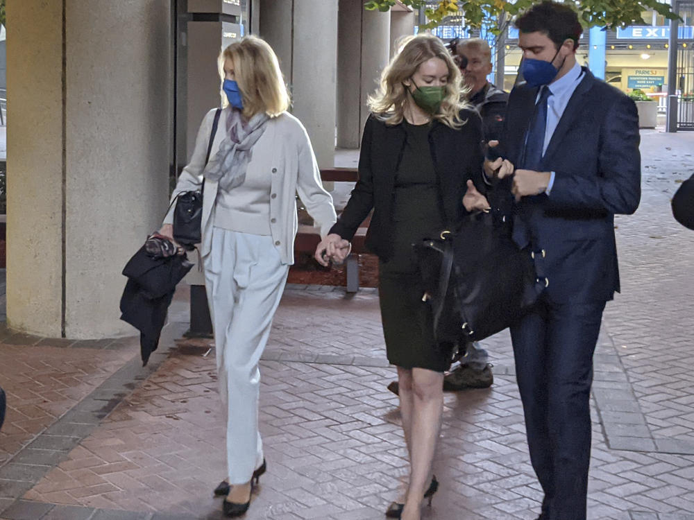 Elizabeth Holmes (center) enters the Robert F. Peckham Federal Building in San Jose, Calif., with her partner, Billy Evans.