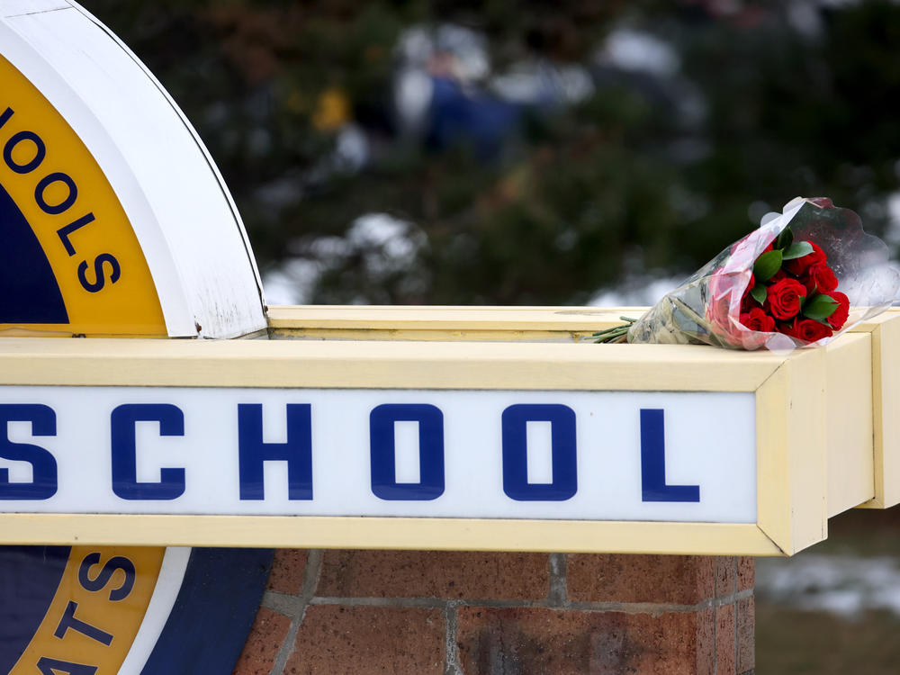 Flowers sit a sign outside Oxford High School a day after a deadly shooting at the school on Dec. 1 in Oxford, Mich.