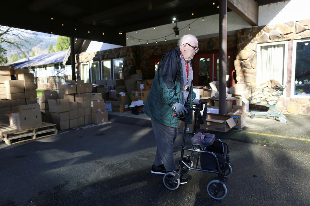 David Crozier walks past piles of donated supplies at Camp Hope after rainstorms caused flooding and landslides that cut off highways across British Columbia, in Hope, Canada Nov. 19. Crozier and his wife Doreen have lived at Camp Hope for months since fleeing wildfires that destroyed the town of Lytton, British Columbia.
