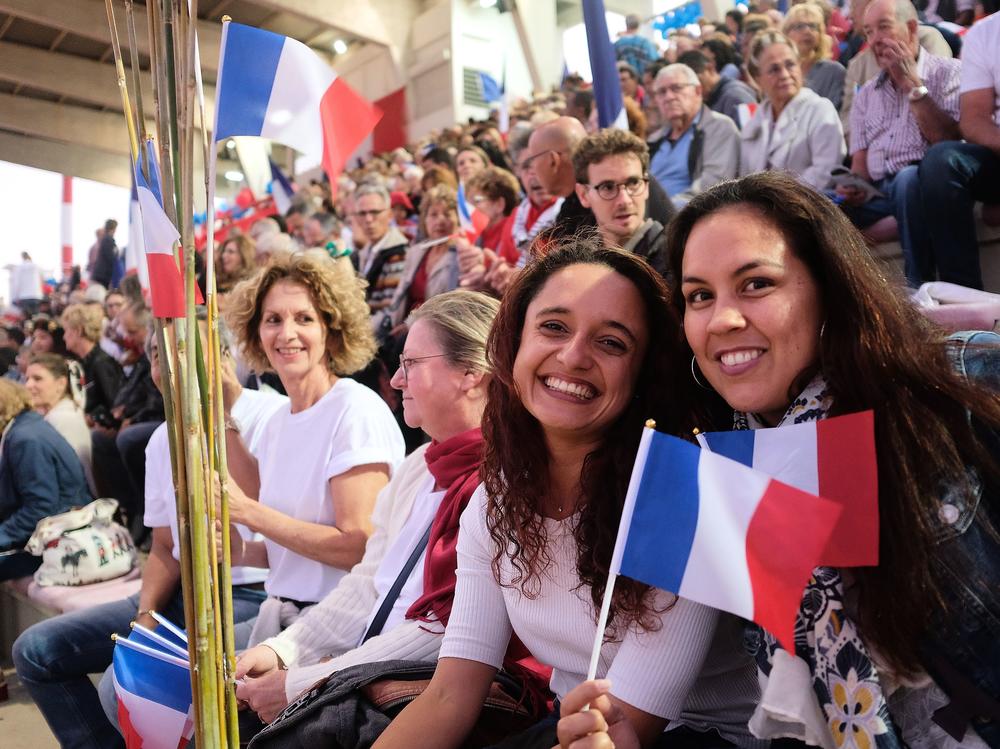 People wave French national flags during the last meeting of the loyalists for the 