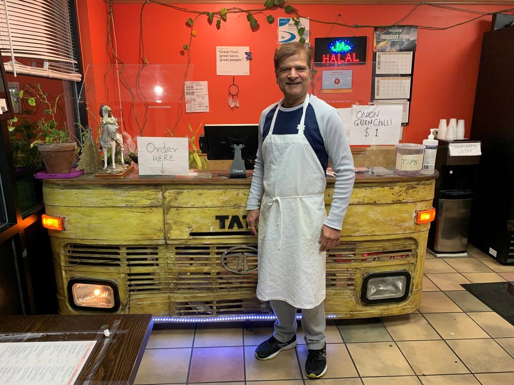 Jagdeep Nayyar, owner and chef at My Taste of India, stands in front of the register stand that's made from the front panel of a real Tata truck — the best-selling brand in India.