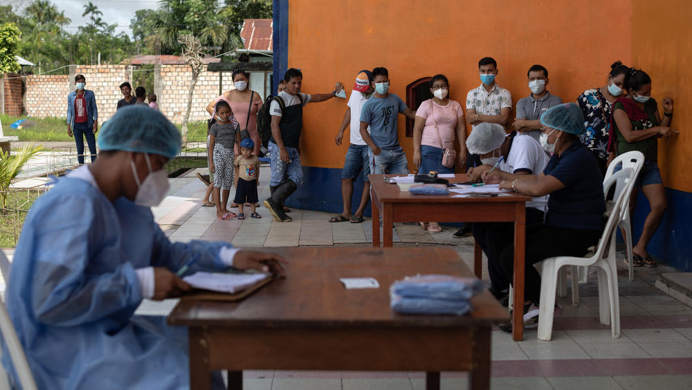 People wait to be vaccinated against COVID 19 in the town of Indiana, Peru.