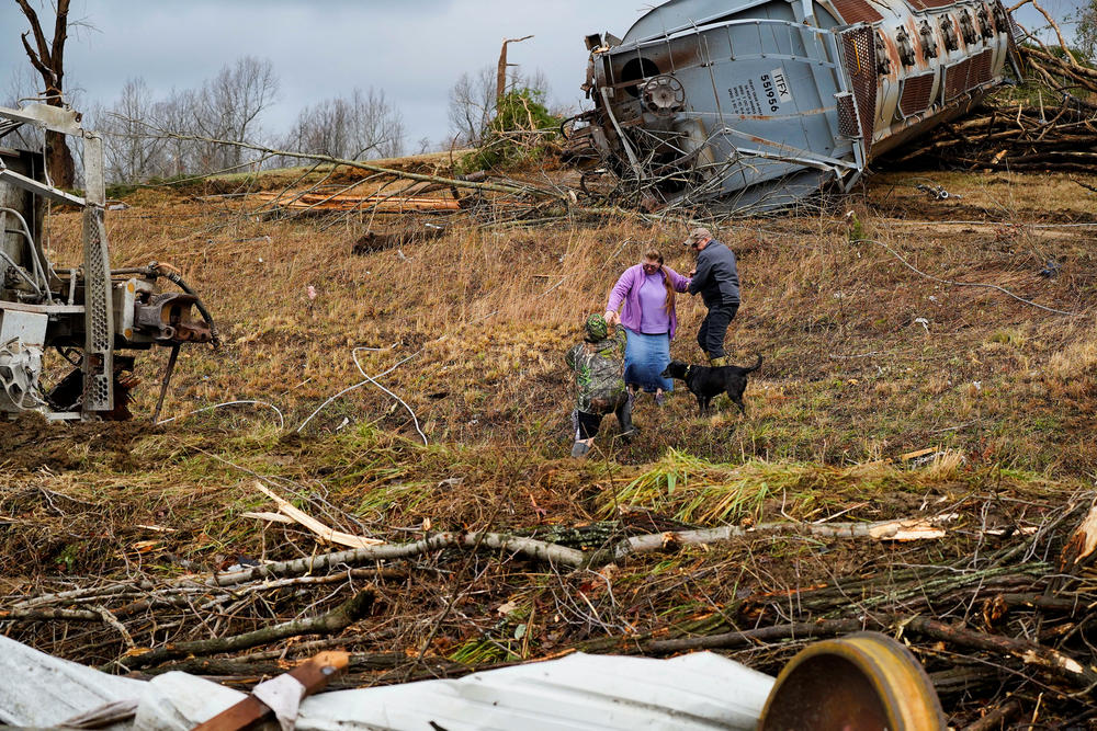 <strong>Sat., Dec. 11: </strong>Local residents walk past the scene of a train derailment after devastating tornadoes in Earlington, Ky.