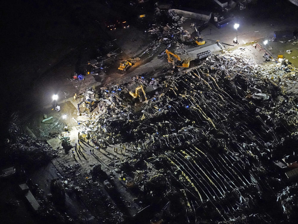 In this aerial photo, a collapsed factory is seen with workers searching for survivors in Mayfield, Ky., on Saturday, after tornadoes came through the area the previous night.