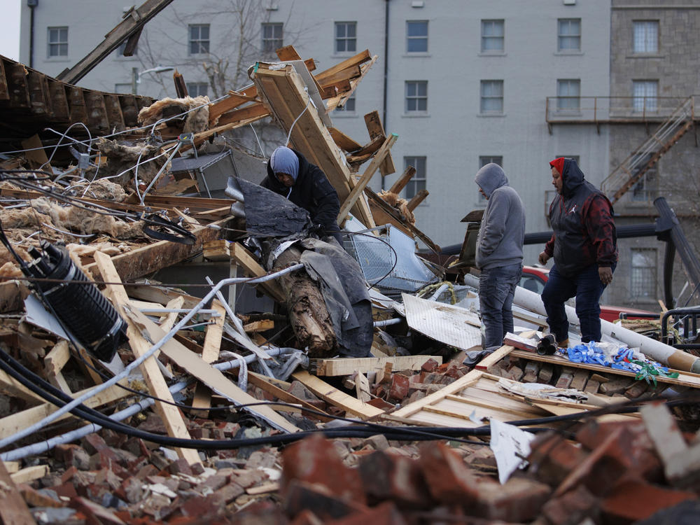 People search through a storm-damaged building on Saturday in Mayfield, Ky. Multiple tornadoes tore through parts of the lower Midwest and South late on Friday night, leaving a large path of destruction.