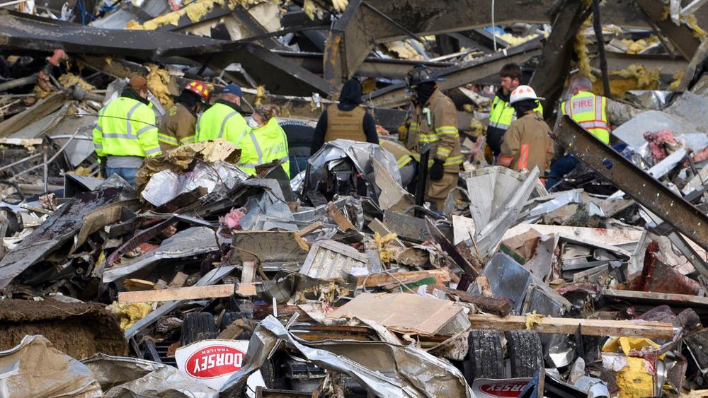 Emergency workers search what is left of the Mayfield Consumer Products Candle Factory on Saturday after it was destroyed in Mayfield, Ky.