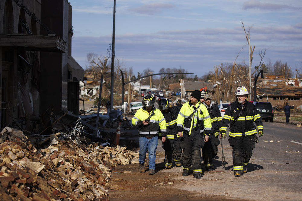 <strong>Sat., Dec. 11:</strong> Firefighters survey tornado damages in downtown Mayfield, Kentucky.