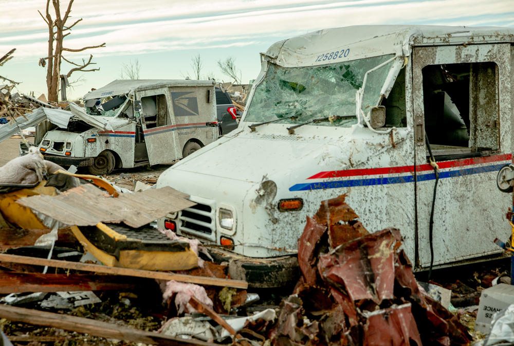 <strong>Sat., Dec. 11:</strong> Damaged USPS trucks sit behind the post office in Mayfield, Kentucky.