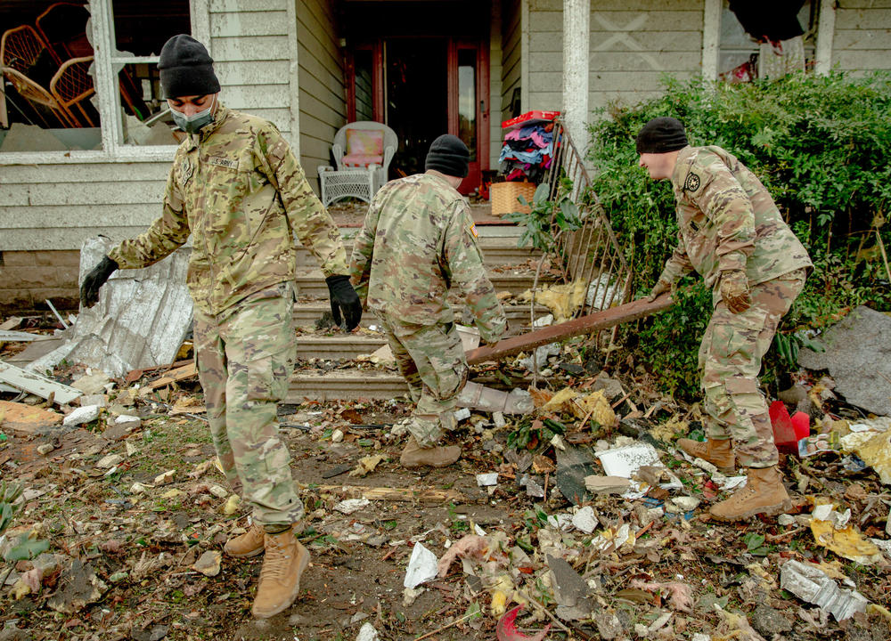 <strong>Sat., Dec. 11:</strong> Staff sergeant Nicholas Sullivan, of Martin, Tennessee, moves debris away from a pathway alongside other U.S. Army volunteers in Mayfield, Kentucky.