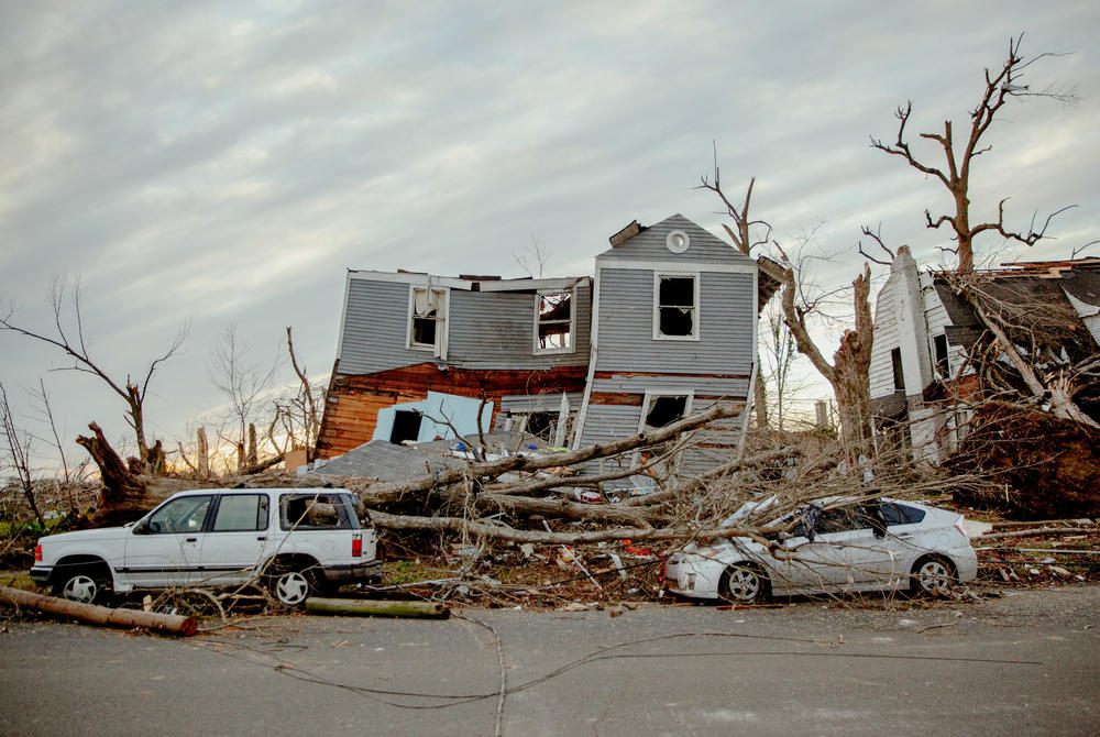 <strong>Sat., Dec. 11:</strong> A damaged home which was lifted from its foundation and vehicles in Mayfield, Kentucky.