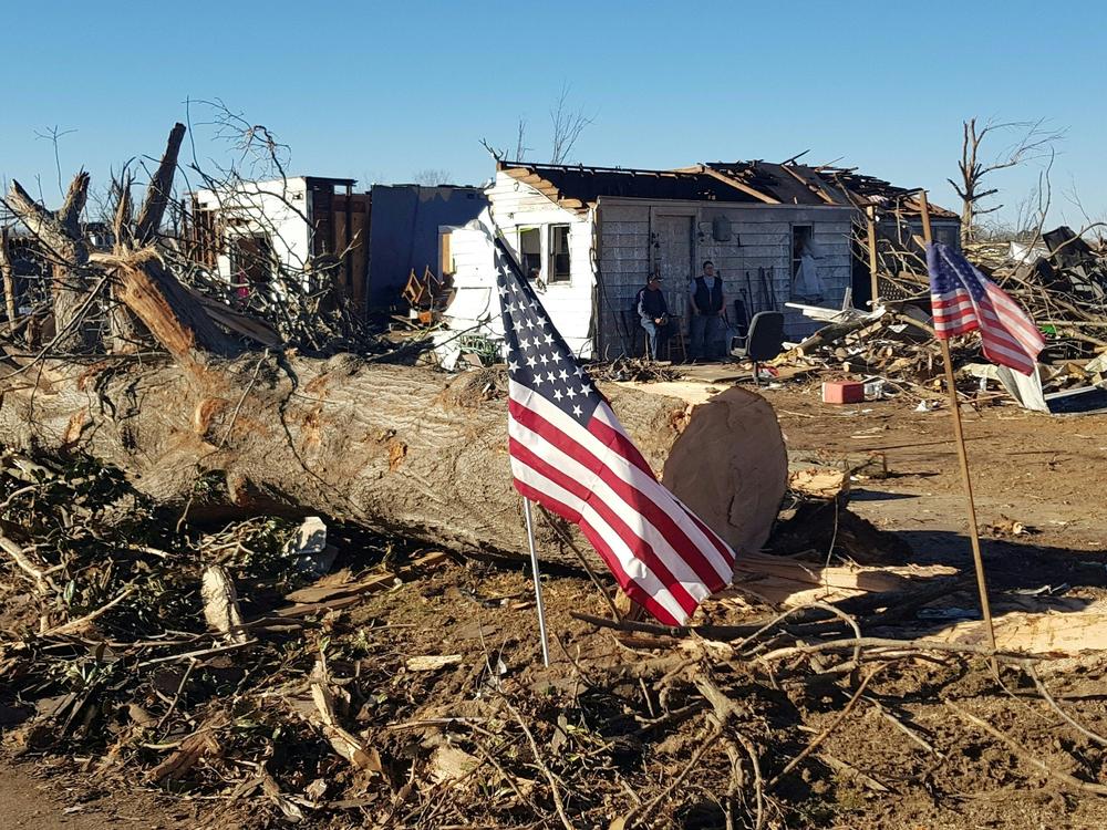 Marty James and a neighbor stand in front of his house in Mayfield, Ky., on Sunday after it was destroyed by a tornado.