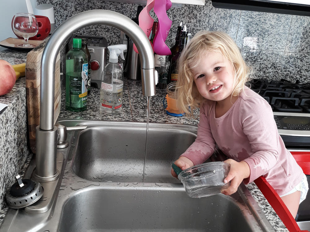 Our correspondent Michaeleen Doucleff's daughter, Rosy, at age 2, as she does dishes voluntarily. Getting her involved in chores did lead to the kitchen being flooded and dishes being broken, Doucleff reports. But Rosy is still eager to help.