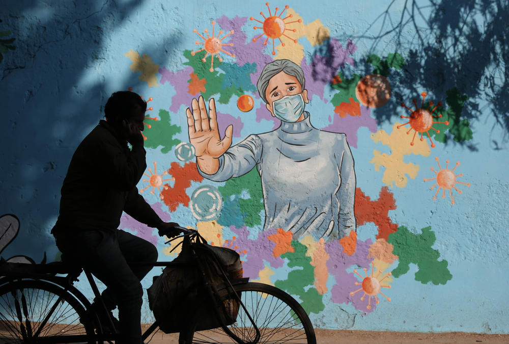 A mural in New Delhi is part of public health messaging in India. The country saw a dramatic decline in new cases since the peaks of fall 2020, but researchers aren't sure why.