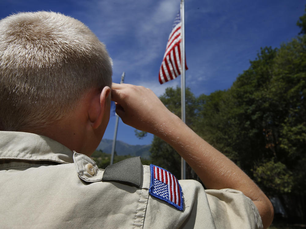 A Boy Scout salutes the American flag at camp Maple Dell in 2015 outside Payson, Utah.