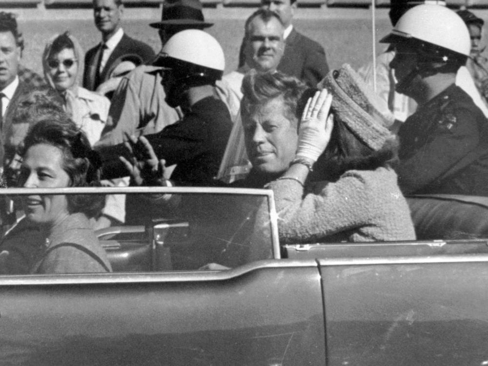 President John F. Kennedy and first lady Jacqueline Kennedy ride in the car in a motorcade in Dallas.