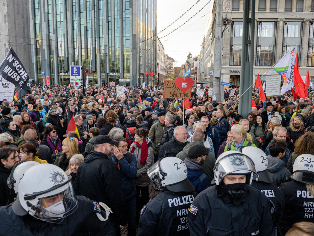 Police stand in front of protesters during a demonstration of Germany's 