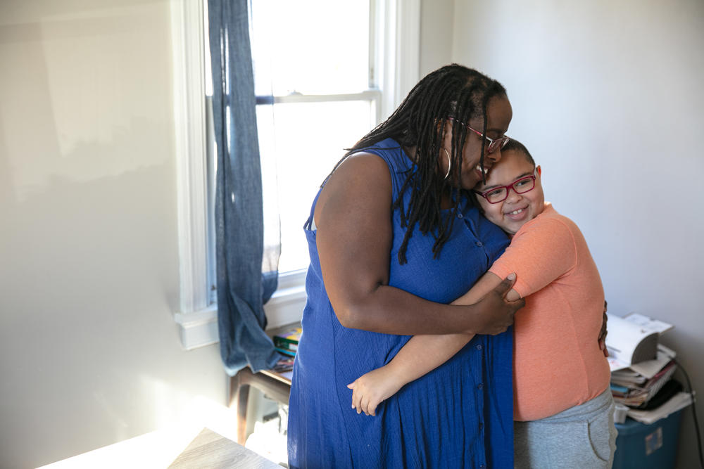 Holly Rodriguez hugs her youngest son, Iommi, at her home in Richmond, Va.