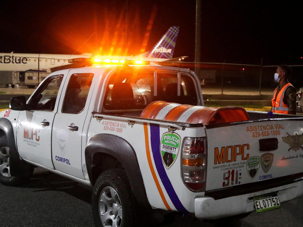 Police stand outside the Las Americas International Airport where a private jet crashed on Wednesday, killing all nine people on board, including Puerto Rican music producer Flow La Movie.