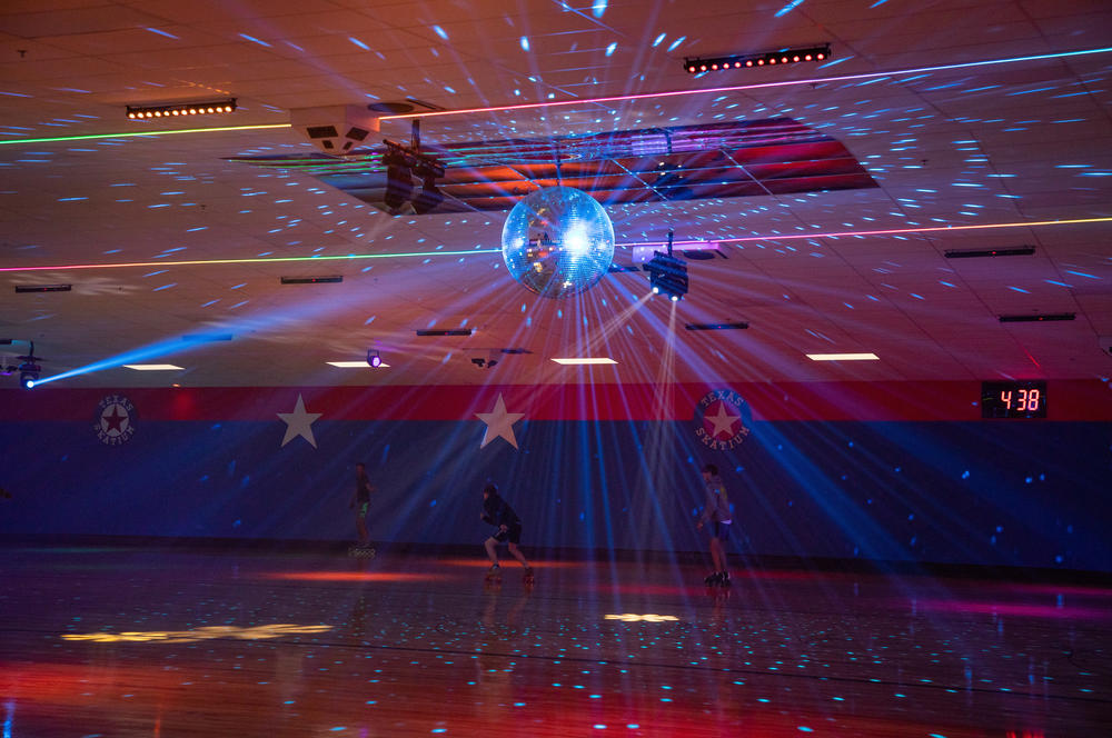 The disco ball shines on rollerbladers on the first evening of the Texas Skatium reopening in Garland, Texas. <a href=