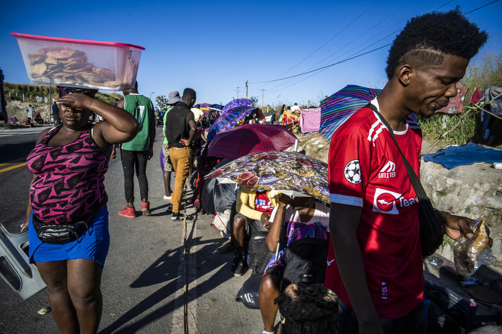 Haitian migrant Djeeff Orelien lines up on the side of a highway for buses provided by the INM, the National Migration Institute, Mexico's immigration agency.