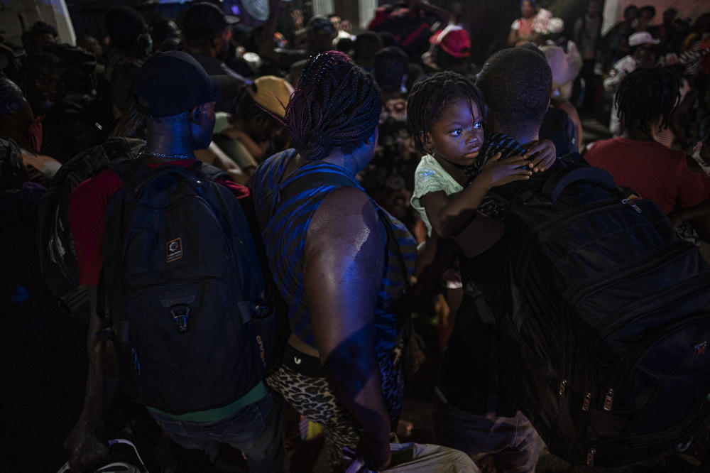 Haitian migrants line up to board buses headed north at an encampment on in Tapachula