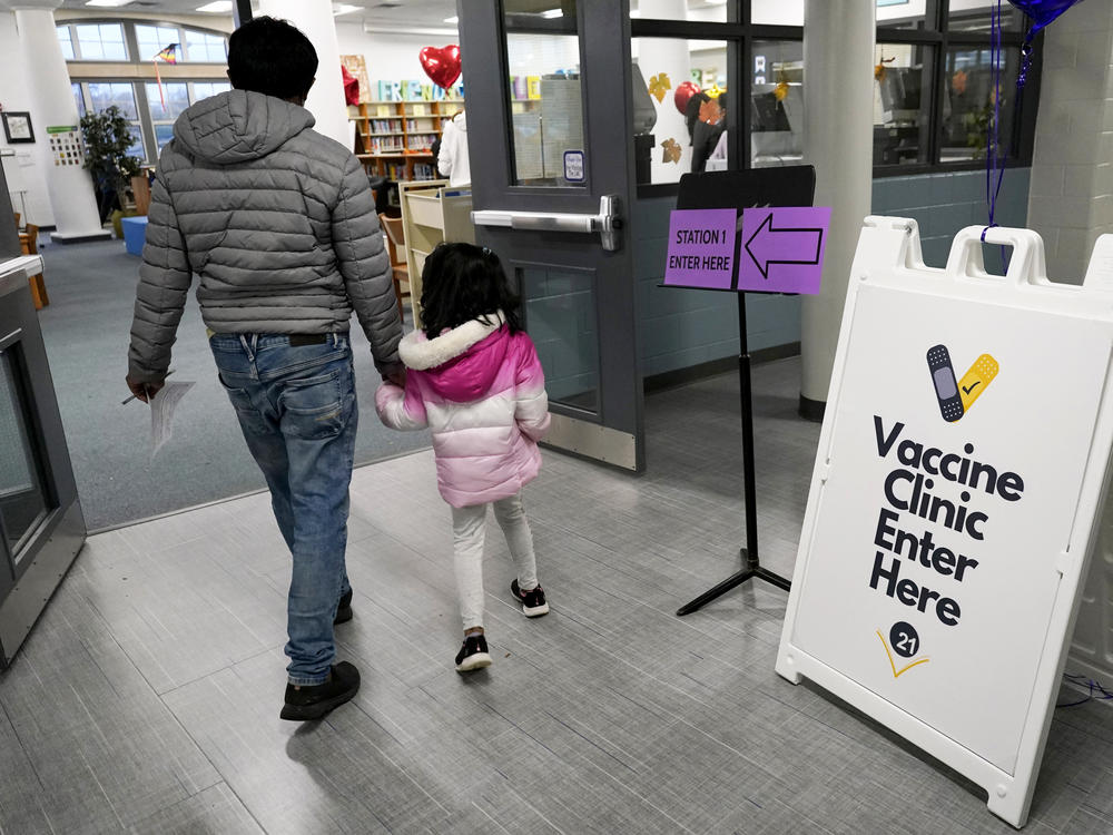 A child, with parent in tow, arrives to receive the Pfizer COVID-19 vaccine for children 5 to 11 years old at London Middle School in Wheeling, Ill., last month.