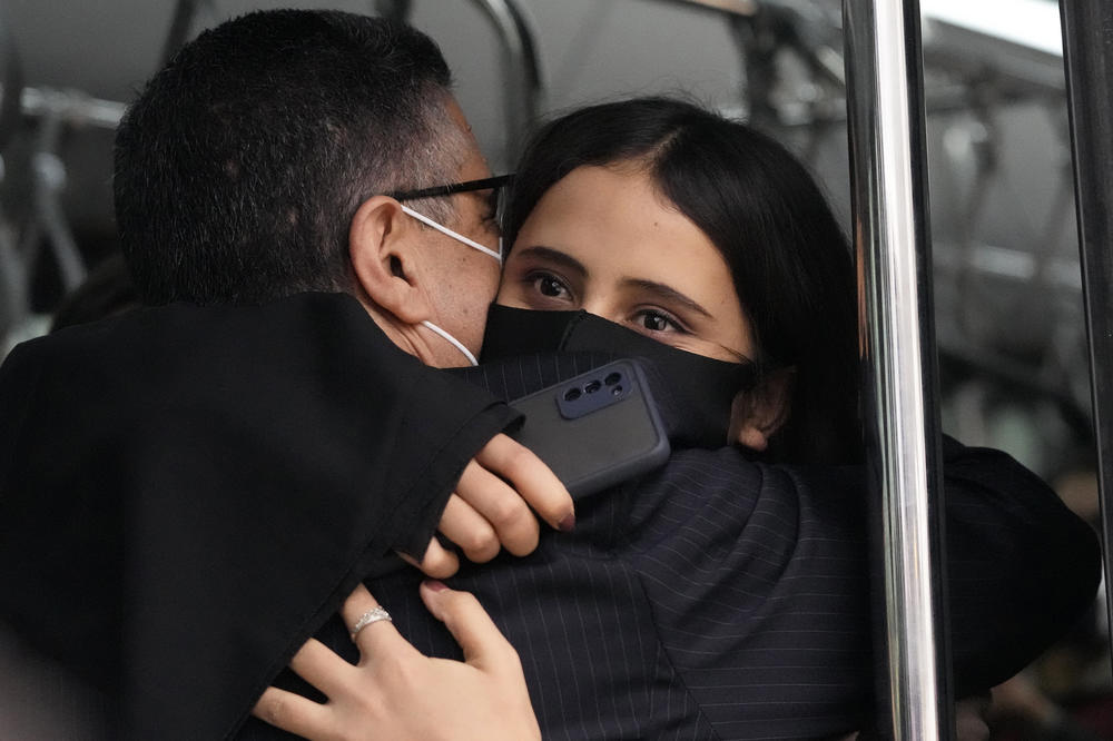 An Afghan musician hugs Ahmad Sarmast, founder and director of the Afghanistan National Institute of Music, inside a bus after she disembarked in Lisbon from the flight from Doha on Dec. 13.