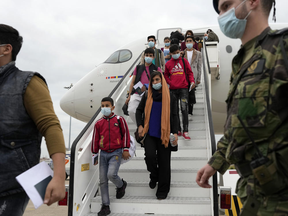 Afghan music students, teachers and their families disembark from their flight to Lisbon on Dec. 13. The group of more than 270 evacuees had been staying in Doha, awaiting resettlement in Portugal.