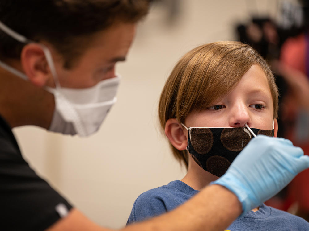 A nurse tests a student for COVID-19 at Brandeis Elementary School in Louisville, Ky.