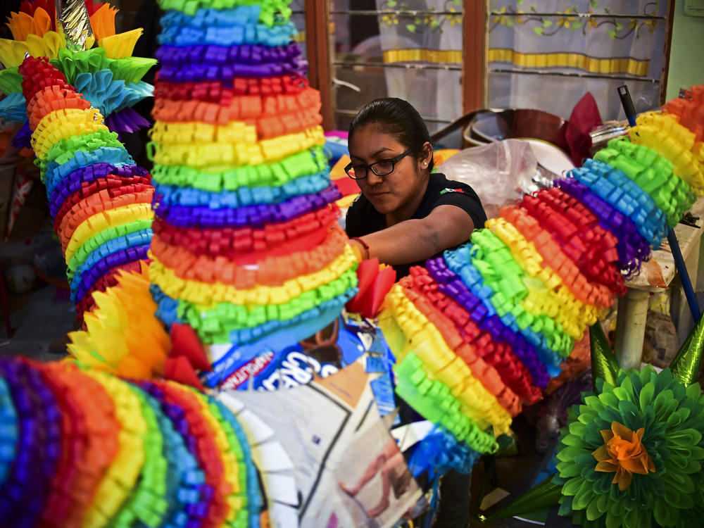 A woman prepares traditional Mexican piñatas for sale at a market in Acolman, Mexico state in 2017.