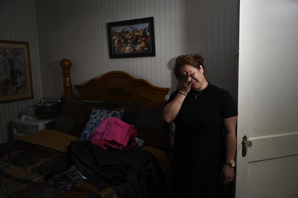 Glenda Cardenas cries after moving clothes from her late husband, Miguel Torres, at their home in Waterbury, Conn. Cardenas, a mother of two, awaits whether she'll be granted legal status in the U.S., or face deportation to Honduras. <a href=