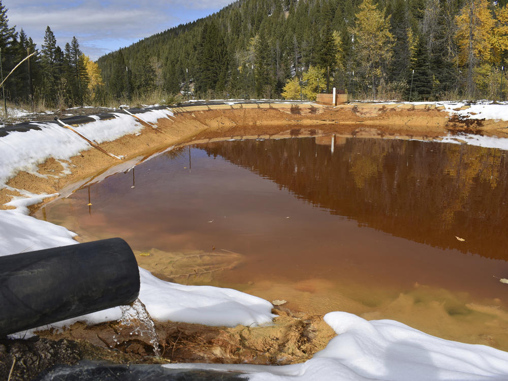 Water contaminated with arsenic, lead and zinc flows from a pipe out of the Lee Mountain mine and into a holding pond near Rimini, Mont., in 2018. It's part of the Upper Tenmile Creek Mining Area Superfund site