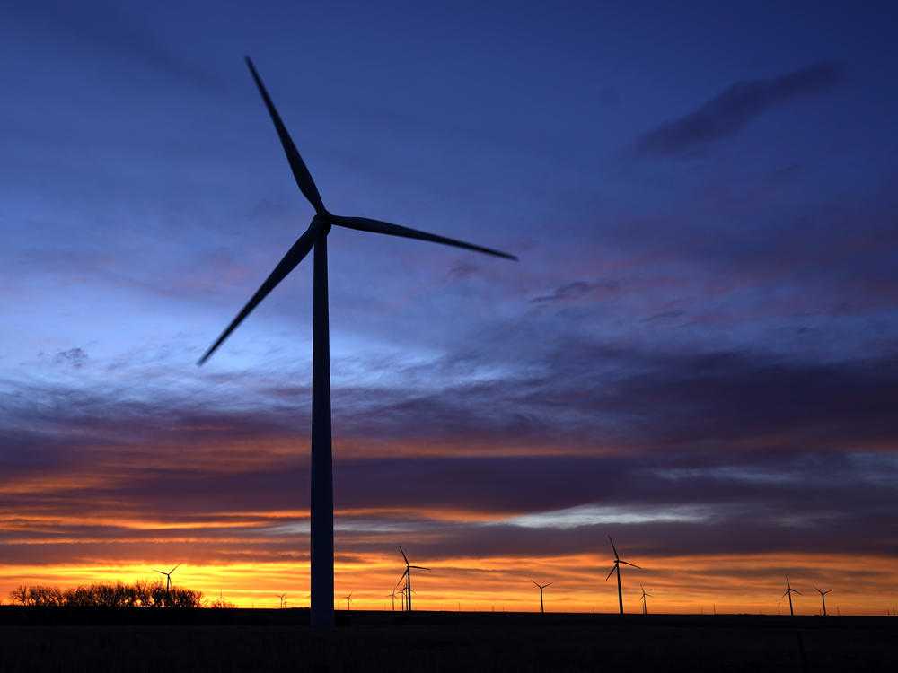Wind turbines silhouetted against the sky at dawn near Spearville, Kan. in January. Senator Joe Manchin's rejection of a sweeping spending bill effectively kills President Biden's ambitious climate plan to transform the nation's heavily fossil-fuel powered economy into a clean-burning one.
