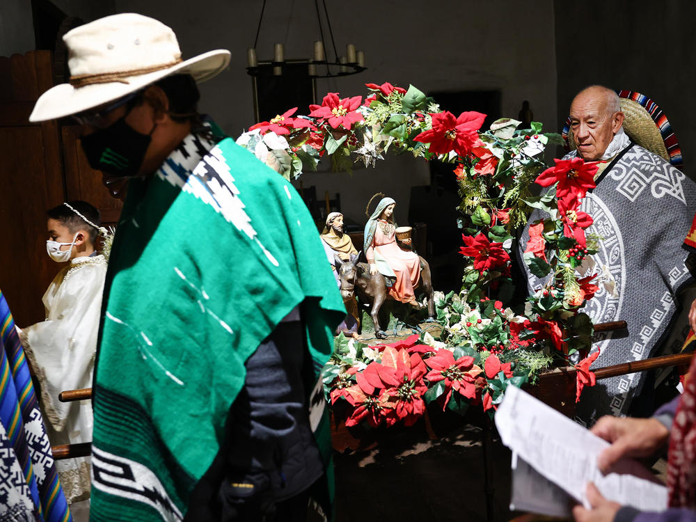 Participants stand in the historic Avila Adobe house, the oldest standing residence in L.A., as they prepare to march in the annual Las Posadas procession on Olvera Street on December 17, 2021 in Los Angeles, California.