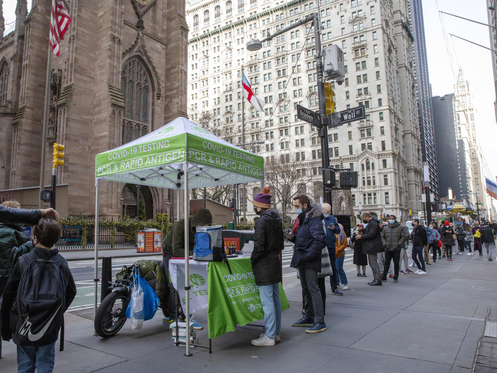 People line up for PCR and rapid antigen coronavirus tests on Wall Street in the Financial District in New York on Thursday.