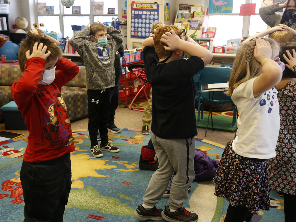 Second-graders hold their heads as they talk about 
