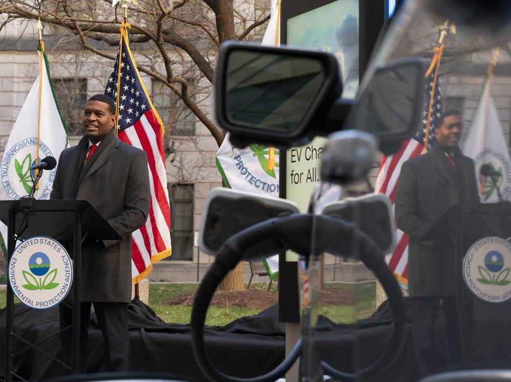 Environmental Protection Agency Administrator Michael Regan is reflected in an electronic vehicle as it charges as he speaks during an event to announce a final rule for federal greenhouse gas emissions standards for cars and trucks on Monday.