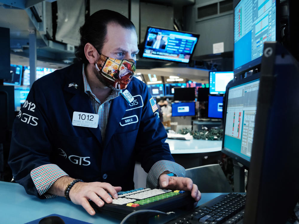 A trader works on the floor of the New York Stock Exchange at the start of trading on Monday. Stocks around the world tumbled over fears of the omicron variant.